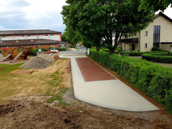 23.05.2022: Blick vom Sonnenhügel, wo später das Waldsofa steht, auf die Mountainbikestrecke im Schatten der Bäume, auf die Asphaltbahn und die Boulebahn. Im Vordergrund der neue Sitzplatz für die Boulespieler. Jetzt ist bis Pfingsten leider Baustopp, wegen Lieferverzögerung der Fertigteile für die Spieltunnel.