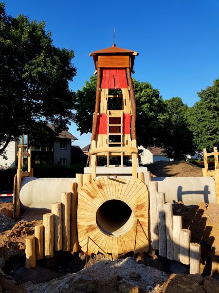 15.06.2022: Es geht weiter. Heute brauchte es Großgerät. Für die Betonfertigteile und den Leuchtturm rückte ein Autokran an. Mit 6m Höhe ist er schon ziemlich hoch. Kletternetz, Kletterwand und Riesenrutsche werden in ein paar Wochen die Kinder erfreuen. Für die drei Tunneleingänge suchen wir noch Namen, z.B. Schatzhöhle, Piratentunnel. Wer hier eine Idee hat, einfach Kommentar mit Namensvorschlag schreiben.
